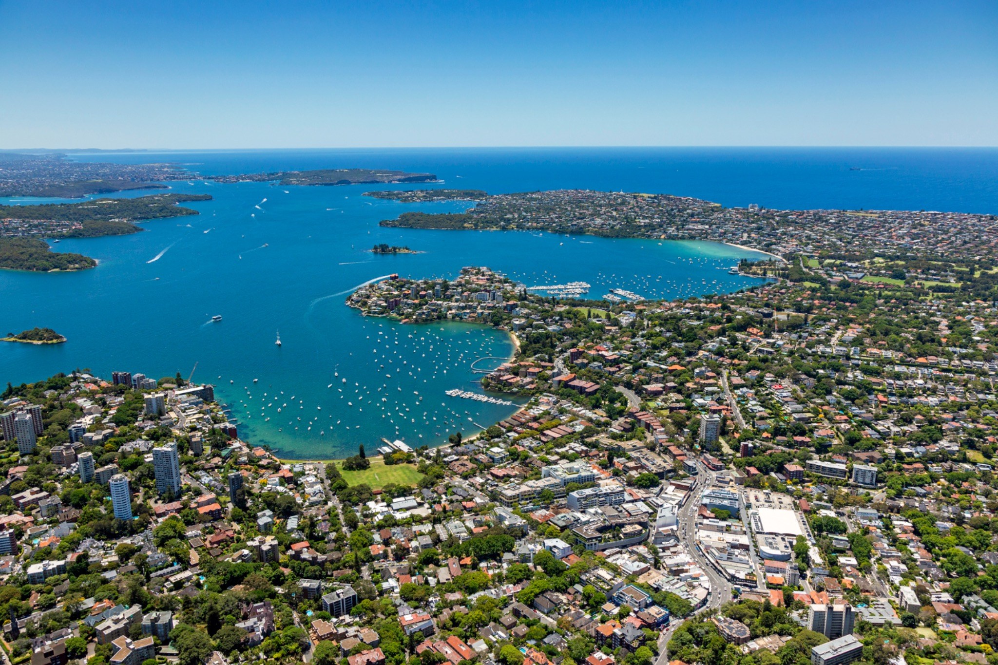 Wide aerial view across Sydney’s harbour and its waterside neighbourhoods